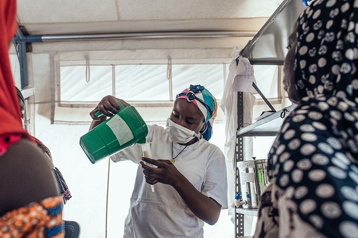 Safaratu Tambaya, som arbetar på Läkare Utan Gränsers undernäringsklinik på Maiyama-sjukhuset i Kebbi, Nigeria, häller upp näringsberikad mjölk som används för att behandla undernäring. Foto: KC NWAKALOR